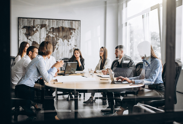 Business team collaborating and sharing ideas at a round table in a professional setting.