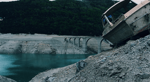 A solitary boat is positioned at the cliff's edge, with a stunning view of the water stretching out beneath it.