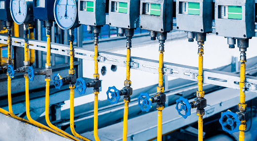 A close-up view of a complex machine featuring various valves and interconnected pipes.